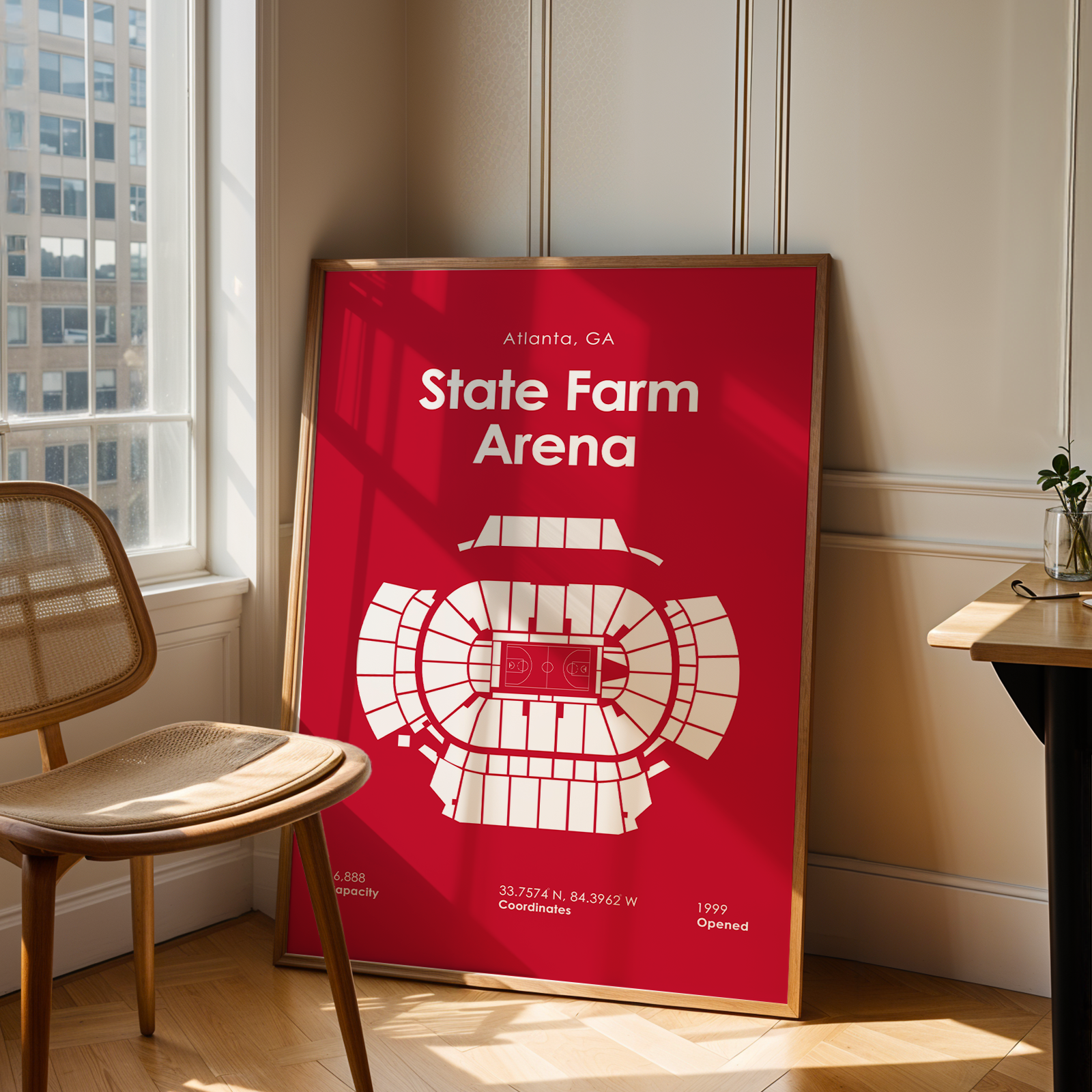 Framed poster of State Farm Arena in a room with a chair and window.