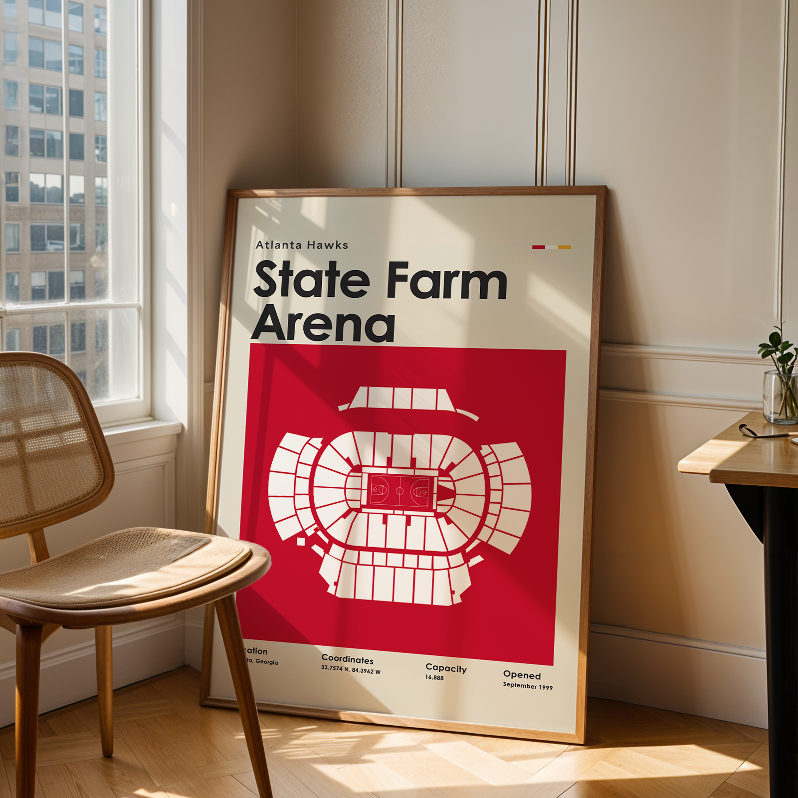Framed poster of State Farm Arena in a room with a chair and window.