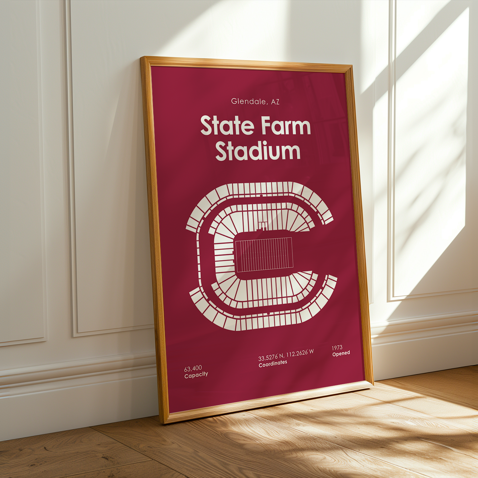 Framed poster of State Farm Stadium on a wall with sunlight casting shadows.