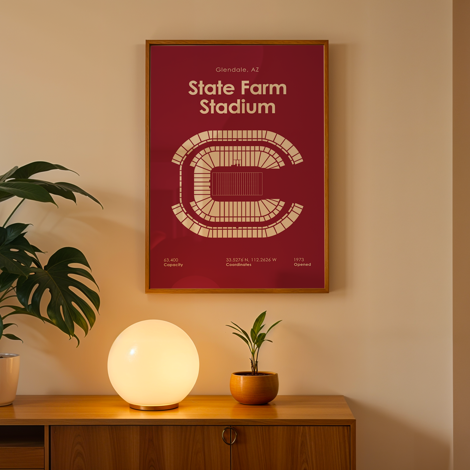 Framed poster of State Farm Stadium on a wall above a wooden cabinet with decorative items.