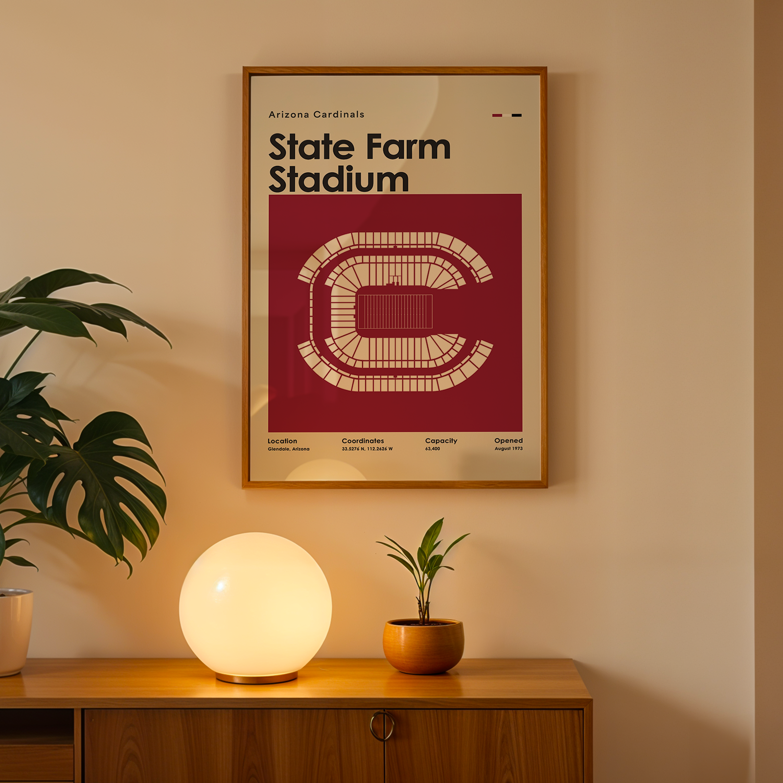 Framed poster of State Farm Stadium on a wall above a wooden cabinet with decorative items.