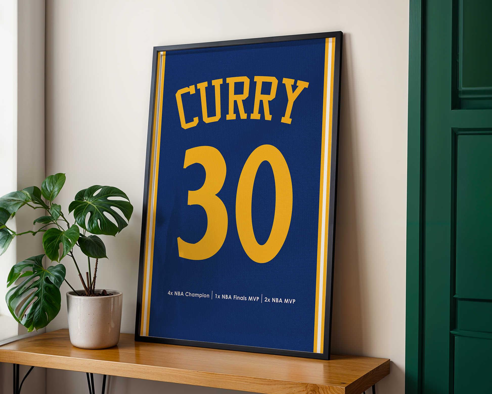 Framed sports jersey with 'Curry 30' on a wooden shelf next to a plant.