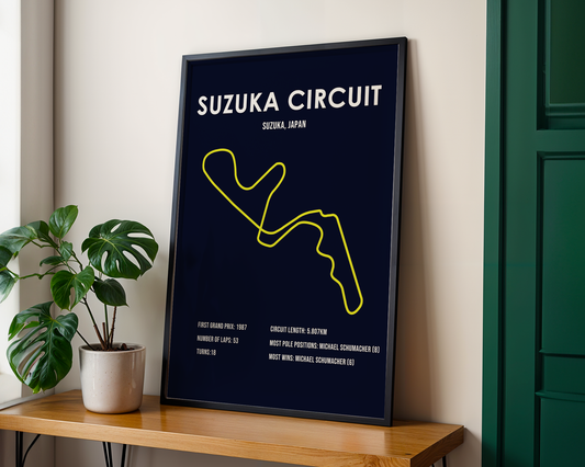 Framed poster of Suzuka Circuit on a wooden shelf with a plant in the background