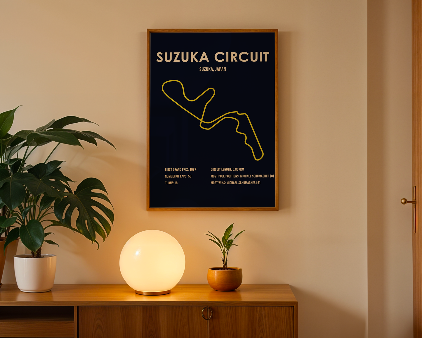 Framed poster of Suzuka Circuit on a wall above a wooden cabinet with decorative items.