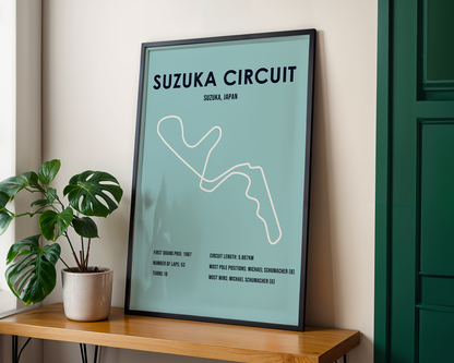 Framed poster of Suzuka Circuit on a wooden shelf with a plant.