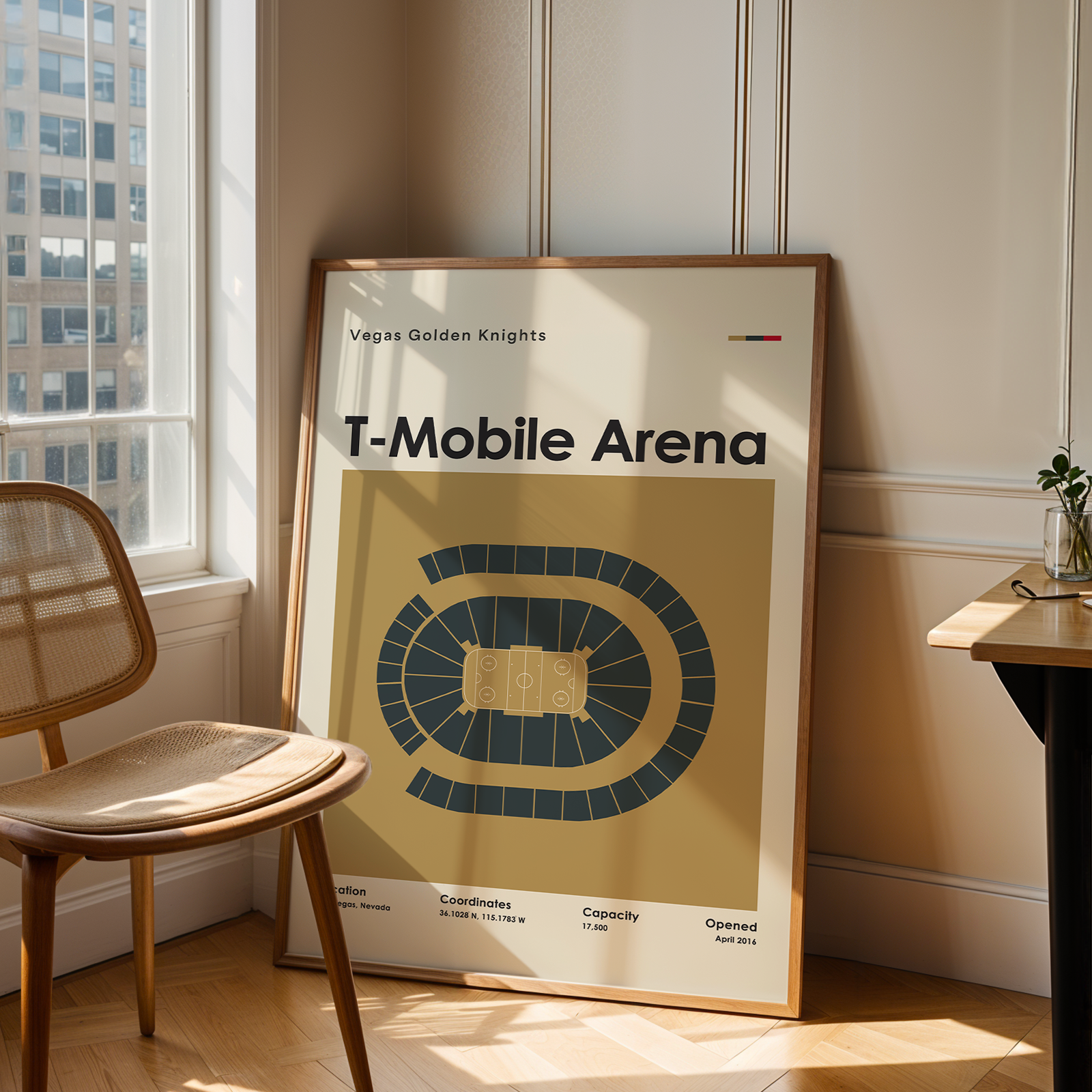 Framed poster of T-Mobile Arena in a room with a chair and table.