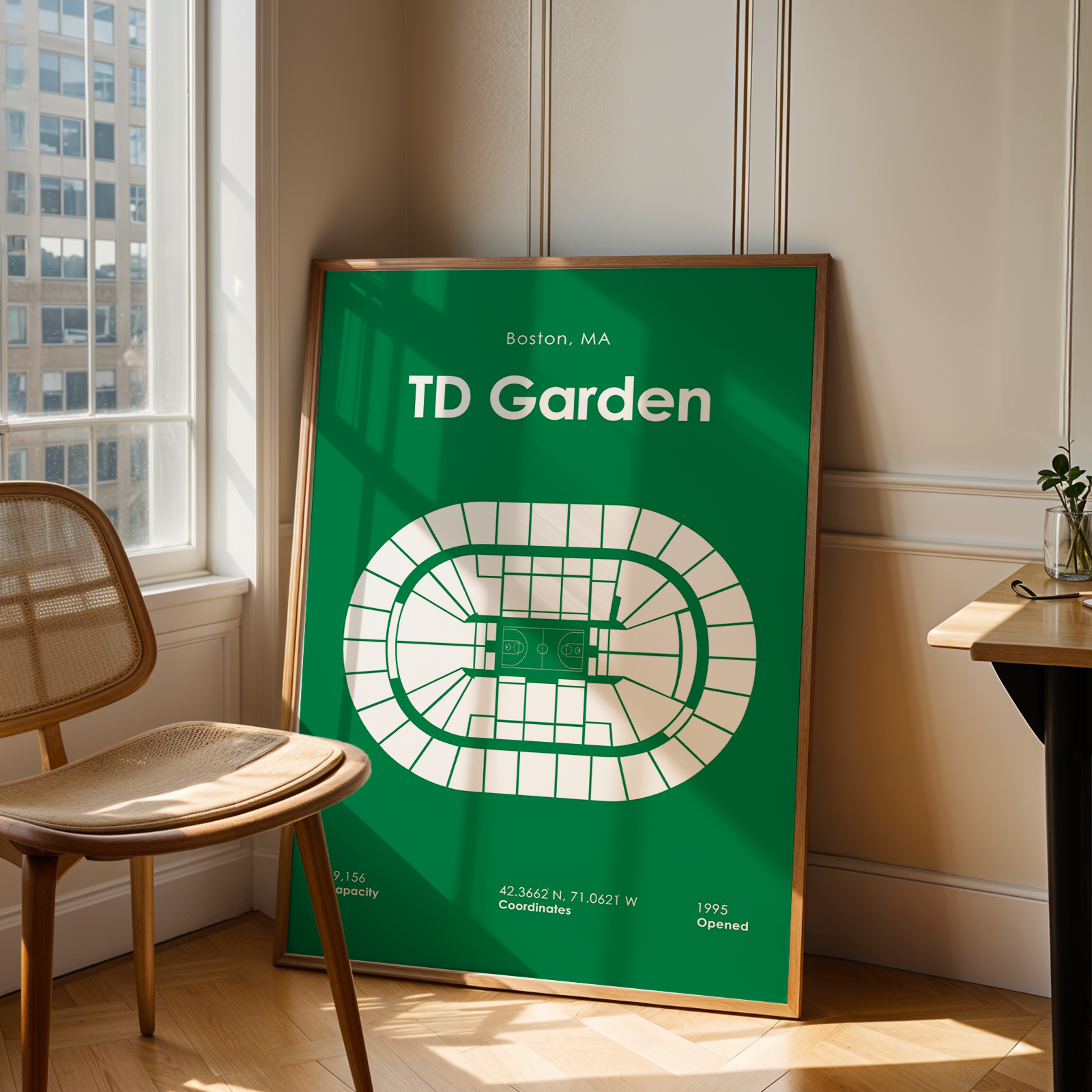 Framed poster of TD Garden in a room with a window and chair.
