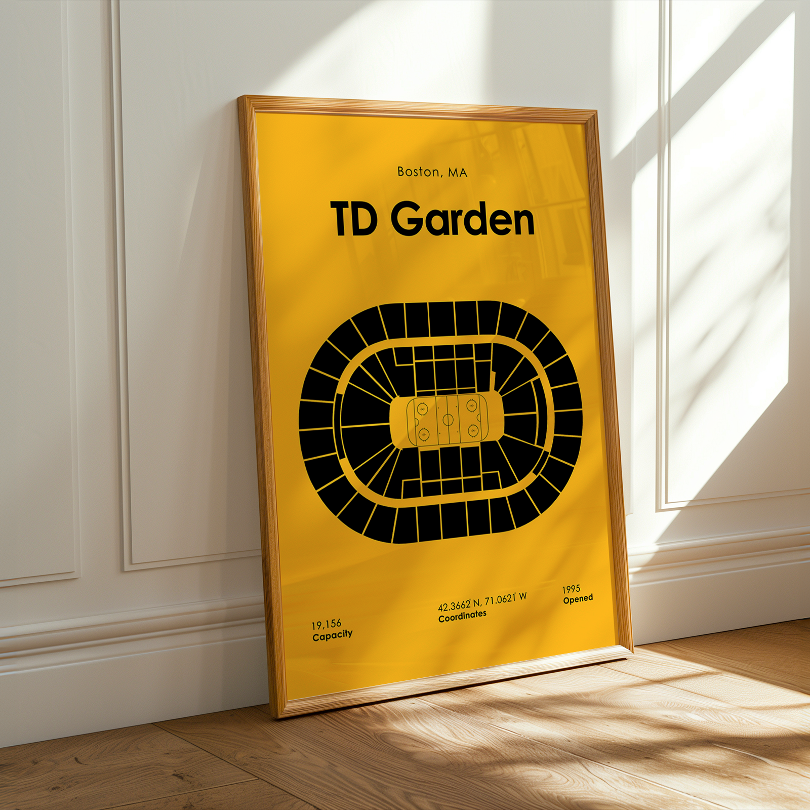 Framed poster of TD Garden layout on a yellow background in a room with sunlight.