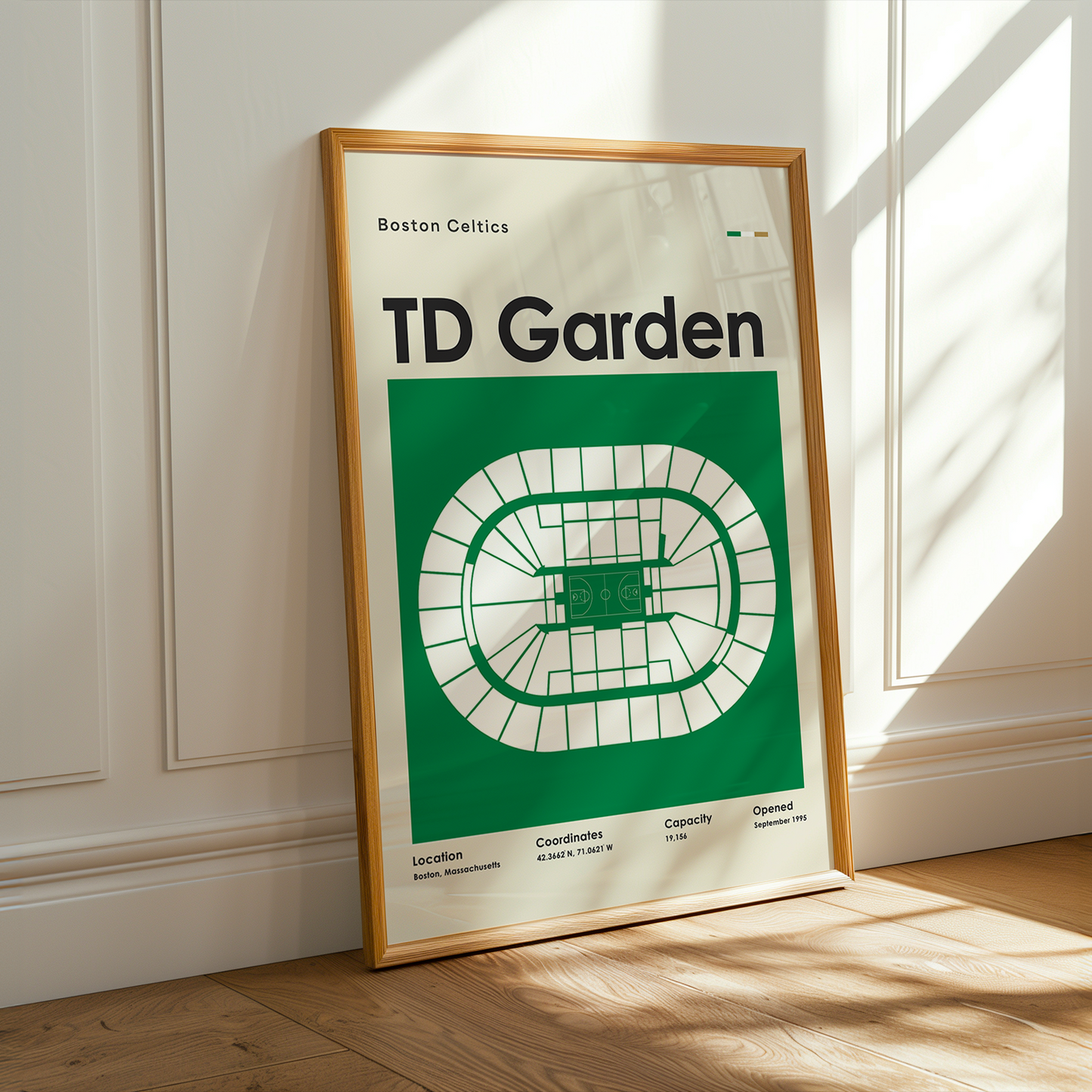Framed poster of TD Garden with wooden frame on a light-colored wall.