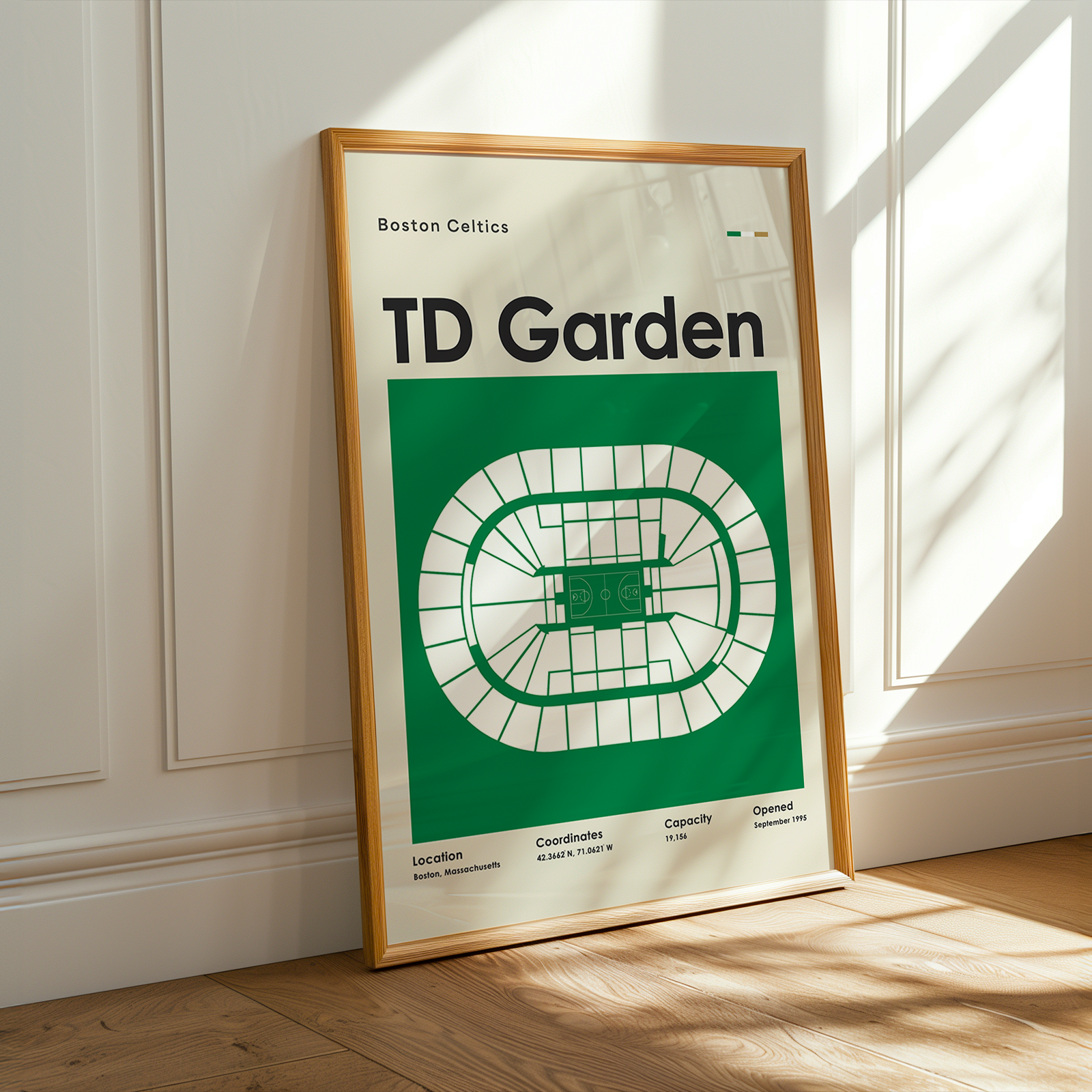 Framed poster of TD Garden with wooden frame on a light-colored wall.