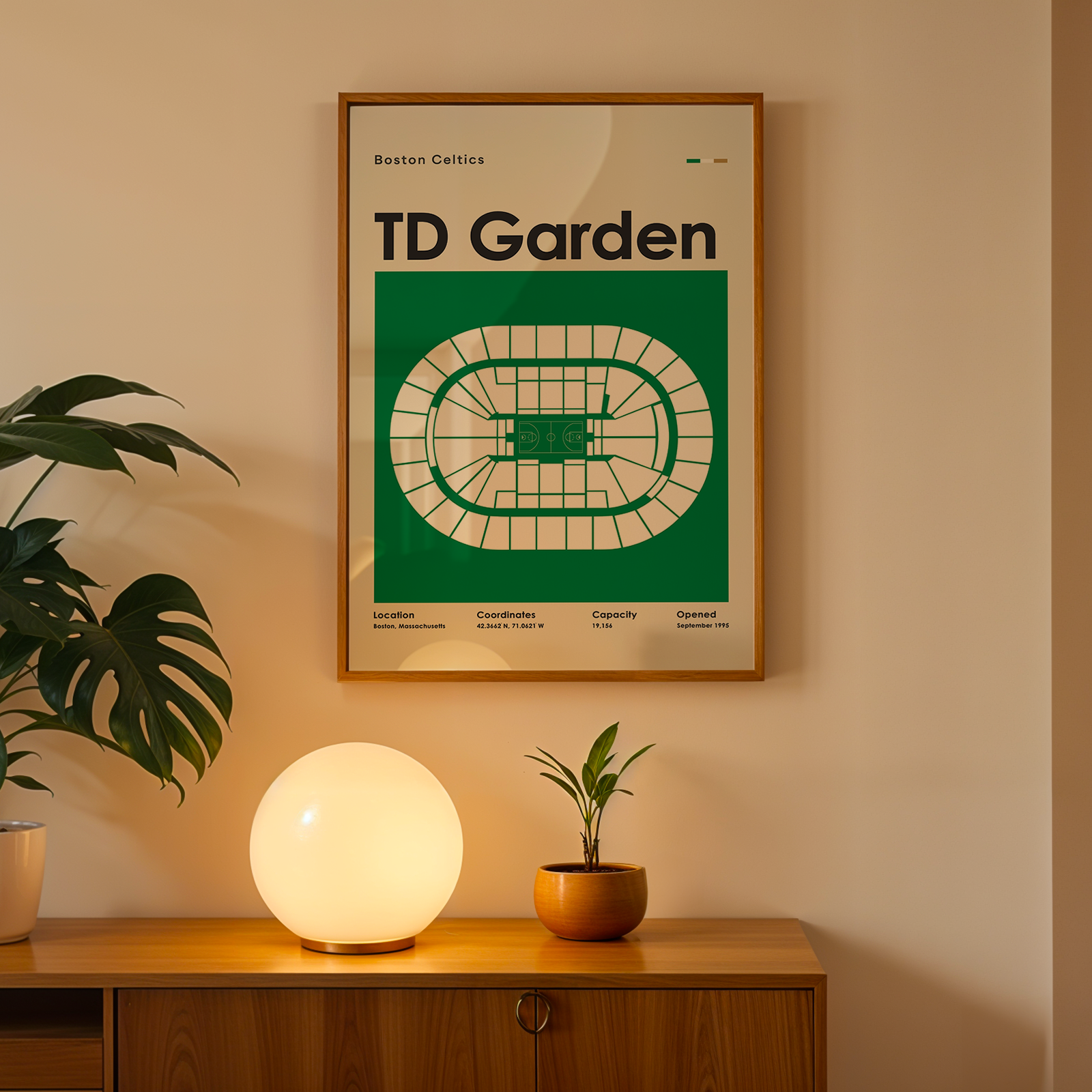 Framed poster of TD Garden on a wall above a wooden cabinet with decorative items.
