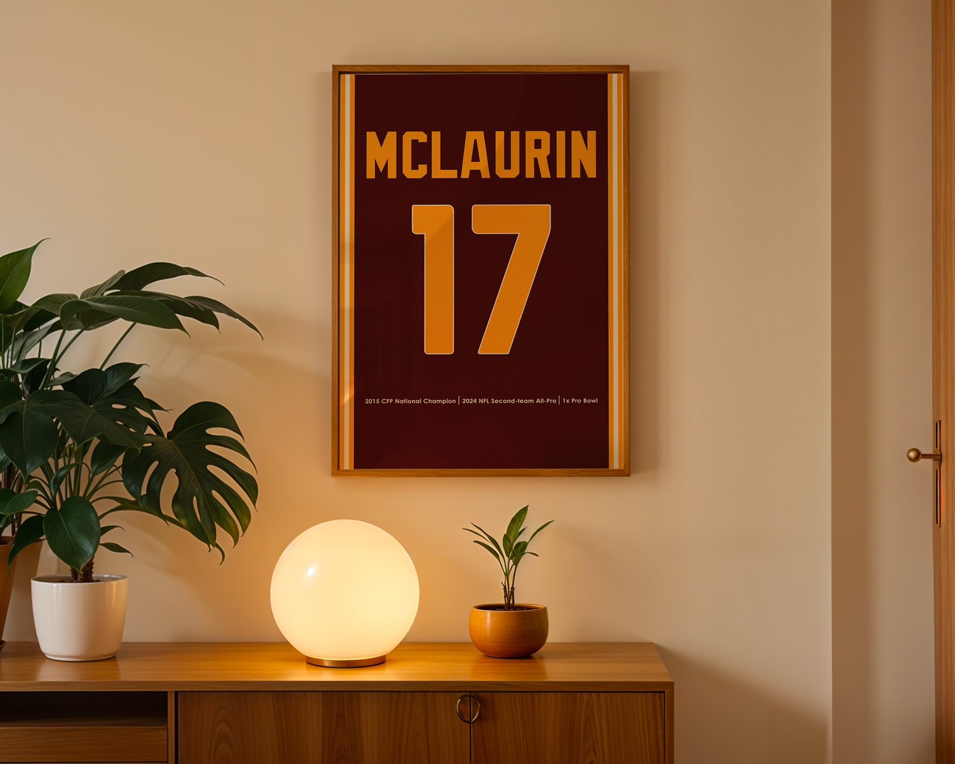 Framed poster with 'MCLAUrin' and number '17' on a wall above a wooden cabinet with decorative items.