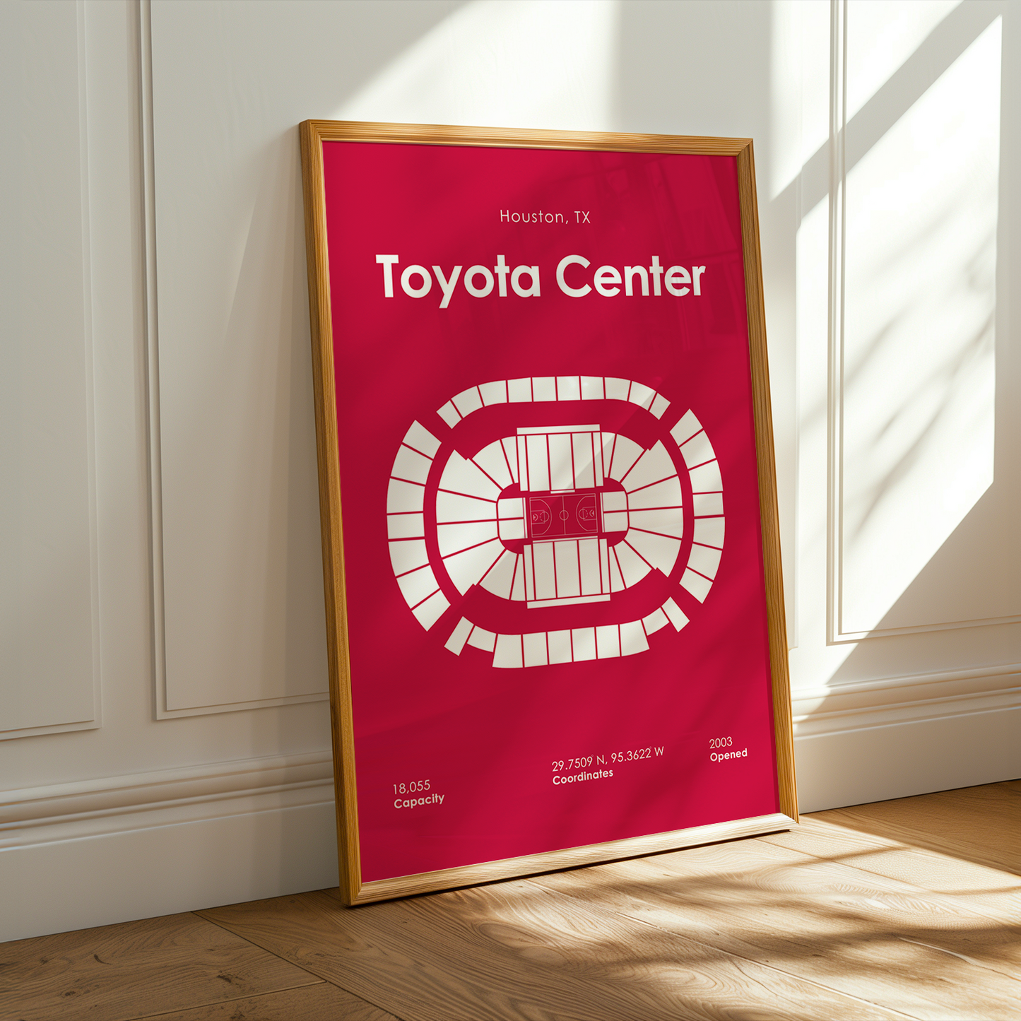 Framed poster of Toyota Center layout on a wall with sunlight casting shadows.