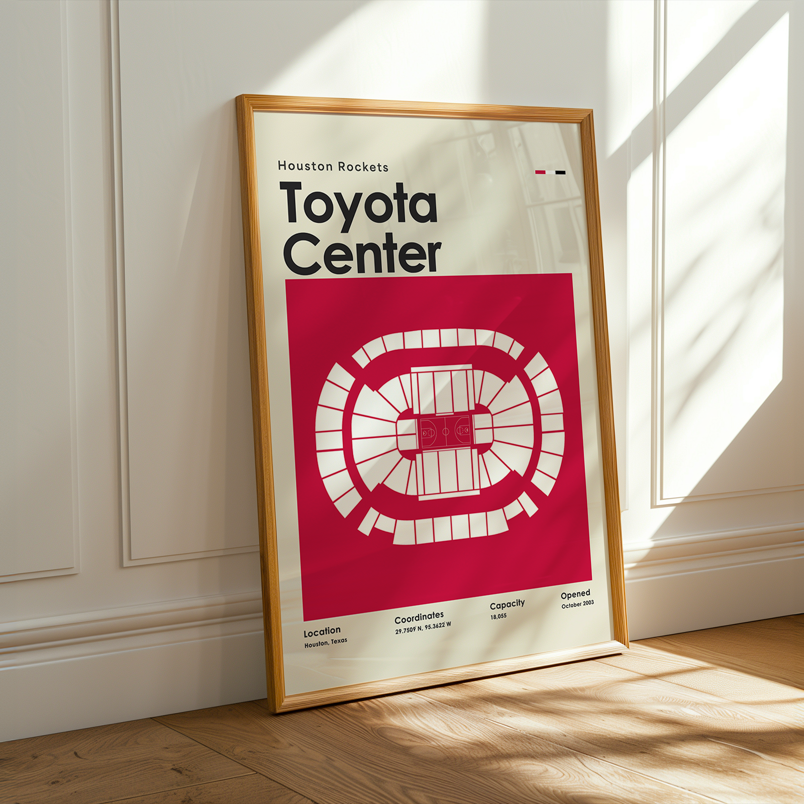 Framed poster of Toyota Center with a red and white design on a wooden floor.