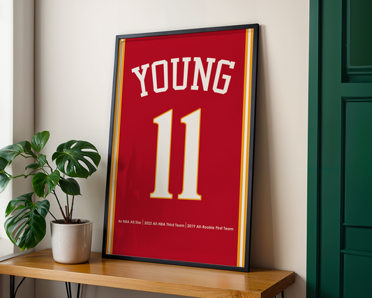Framed red sports jersey with 'YOUNG' and number '11' on a wooden table.