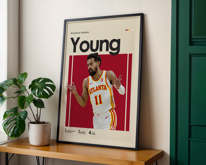 Framed poster of a basketball player with 'Young' and 'Atlanta Hawks' text, placed on a wooden surface.