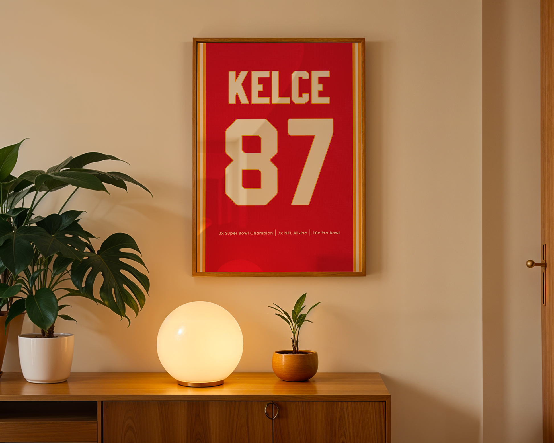 Framed poster with 'KELCE 87' on a wall above a wooden cabinet with decorative items.