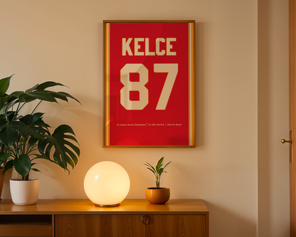 Framed poster with 'KELCE 87' on a wall above a wooden cabinet with decorative items.
