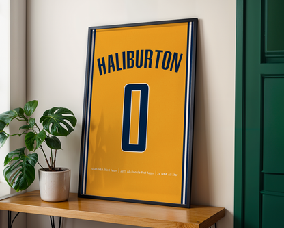 Framed poster with 'Haliburton' and number '0' on a yellow background, placed on a wooden shelf.