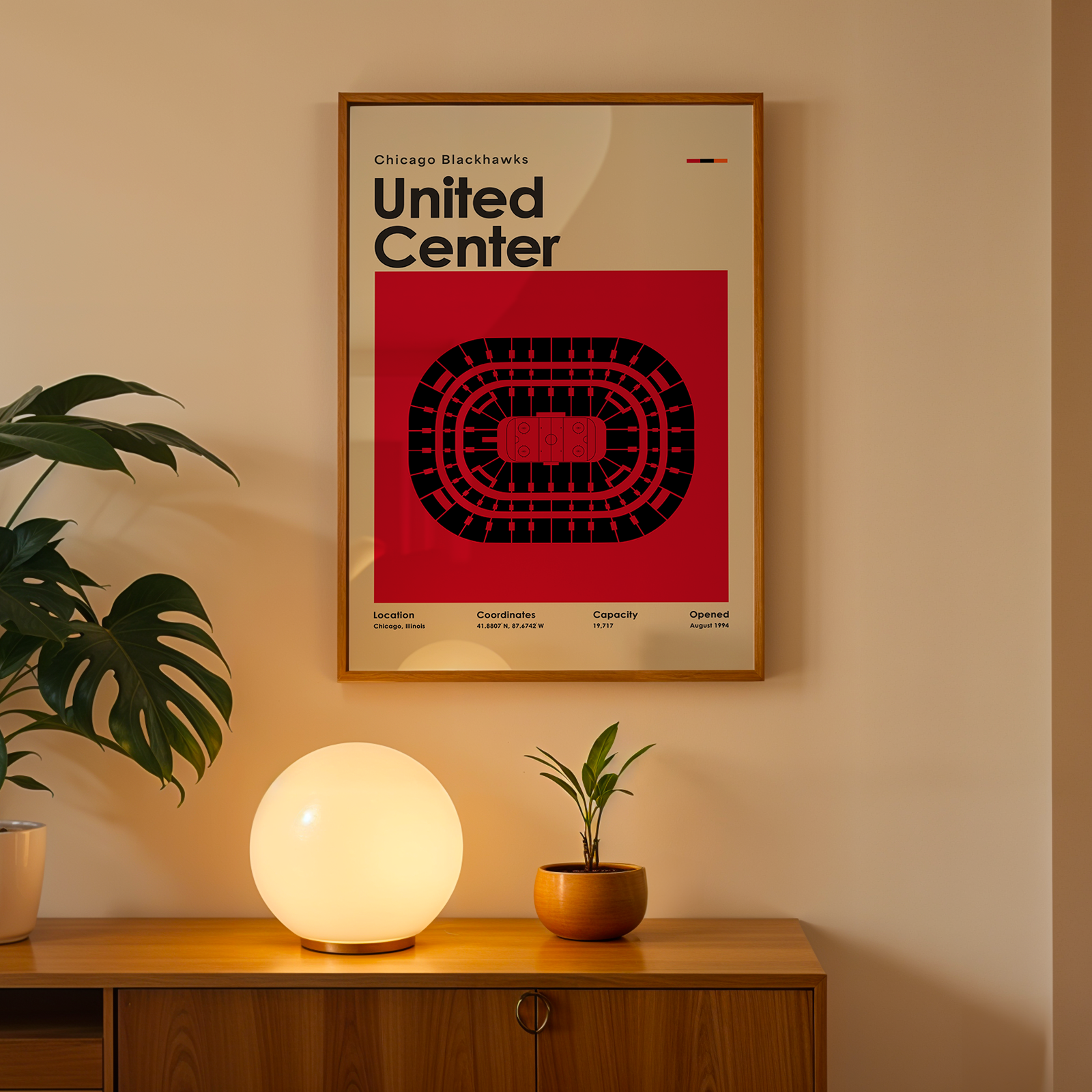 Framed poster of United Center on a wall above a wooden cabinet with decorative items.