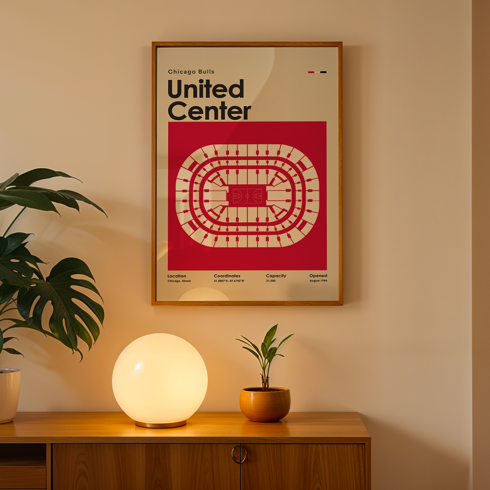 Framed poster of United Center on a wall above a wooden cabinet with decorative items.