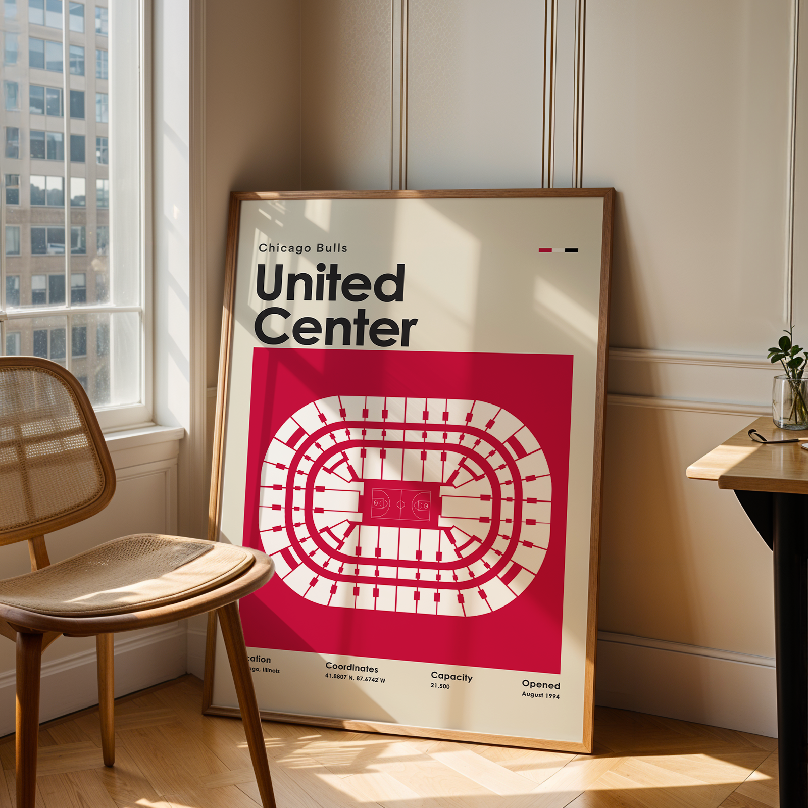 Framed poster of the United Center layout in a room with a chair and table.