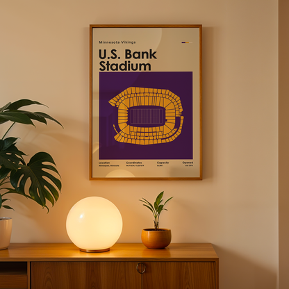Framed poster of U.S. Bank Stadium on a wall above a wooden cabinet with decorative items.
