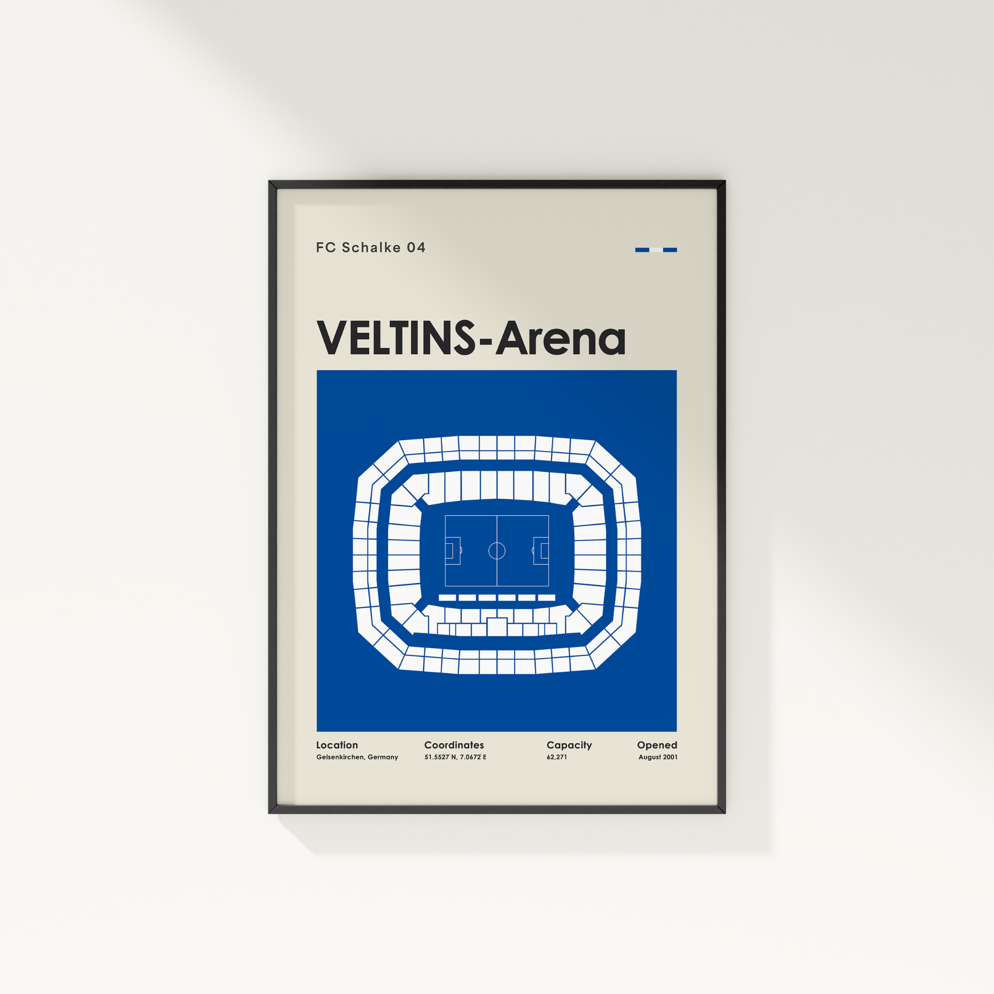 A framed minimalist sports poster for FC Schalke 04 Veltins-Arena, featuring a blue and white stadium diagram on a light beige background, mounted on a white wall.