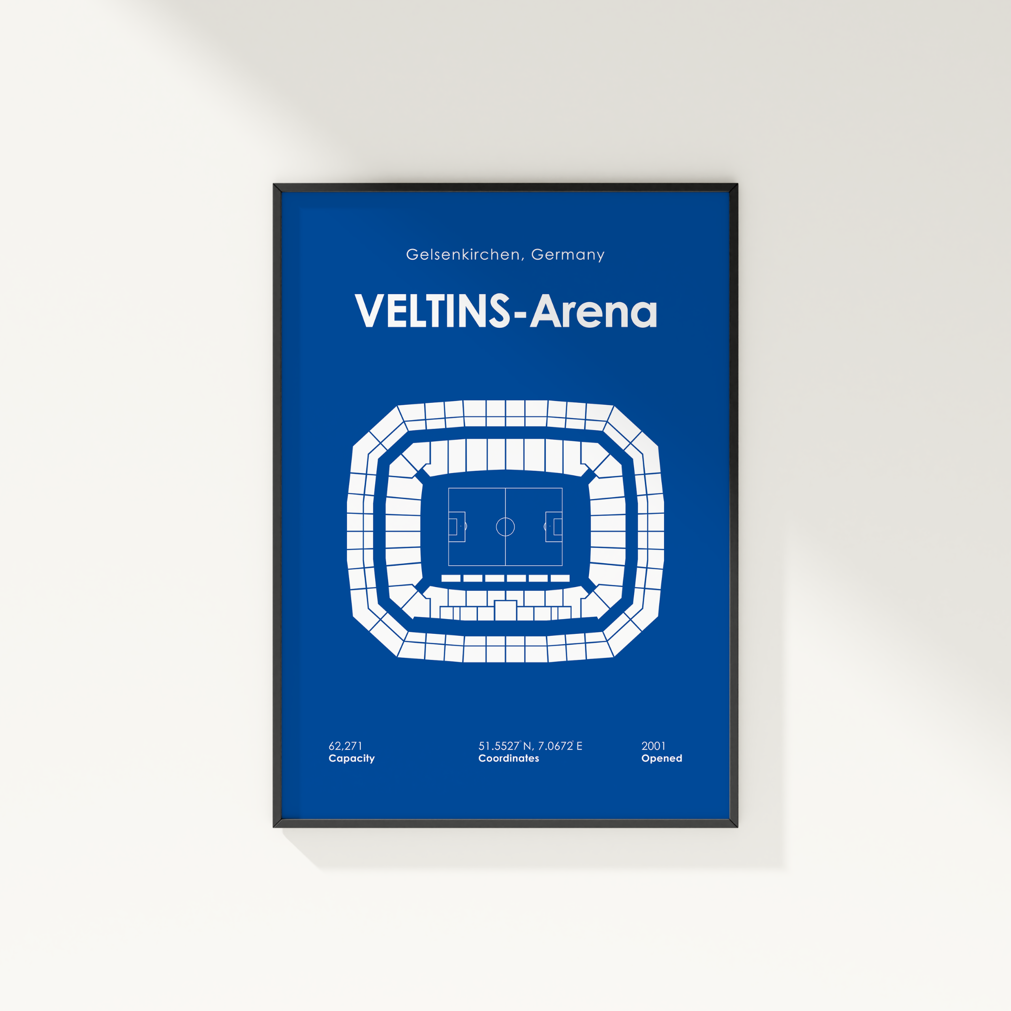 A framed blue and white Veltins-Arena stadium map poster, displayed on a clean white wall with a soft shadow.