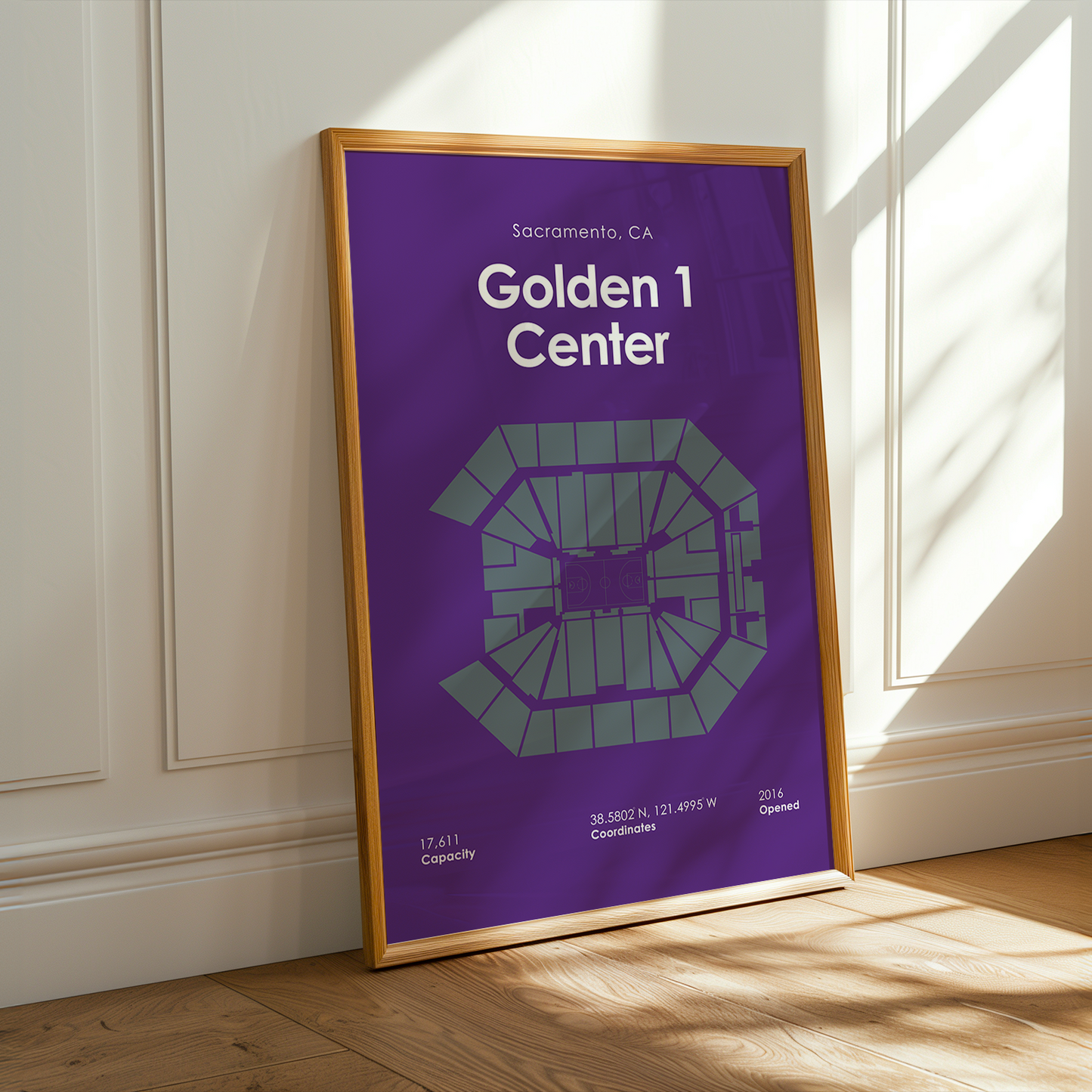 Framed poster of Golden 1 Center in a room with sunlight streaming through a window.