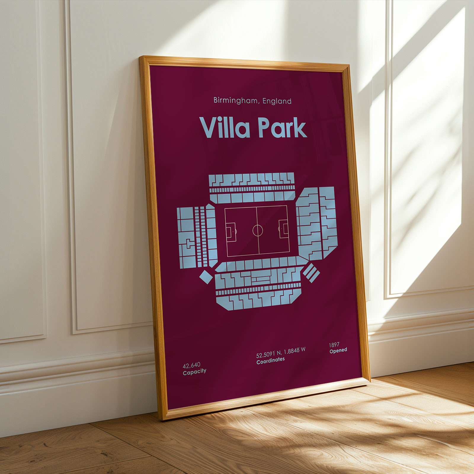 Framed poster of Villa Park stadium layout on a purple background, leaning against a white wall.