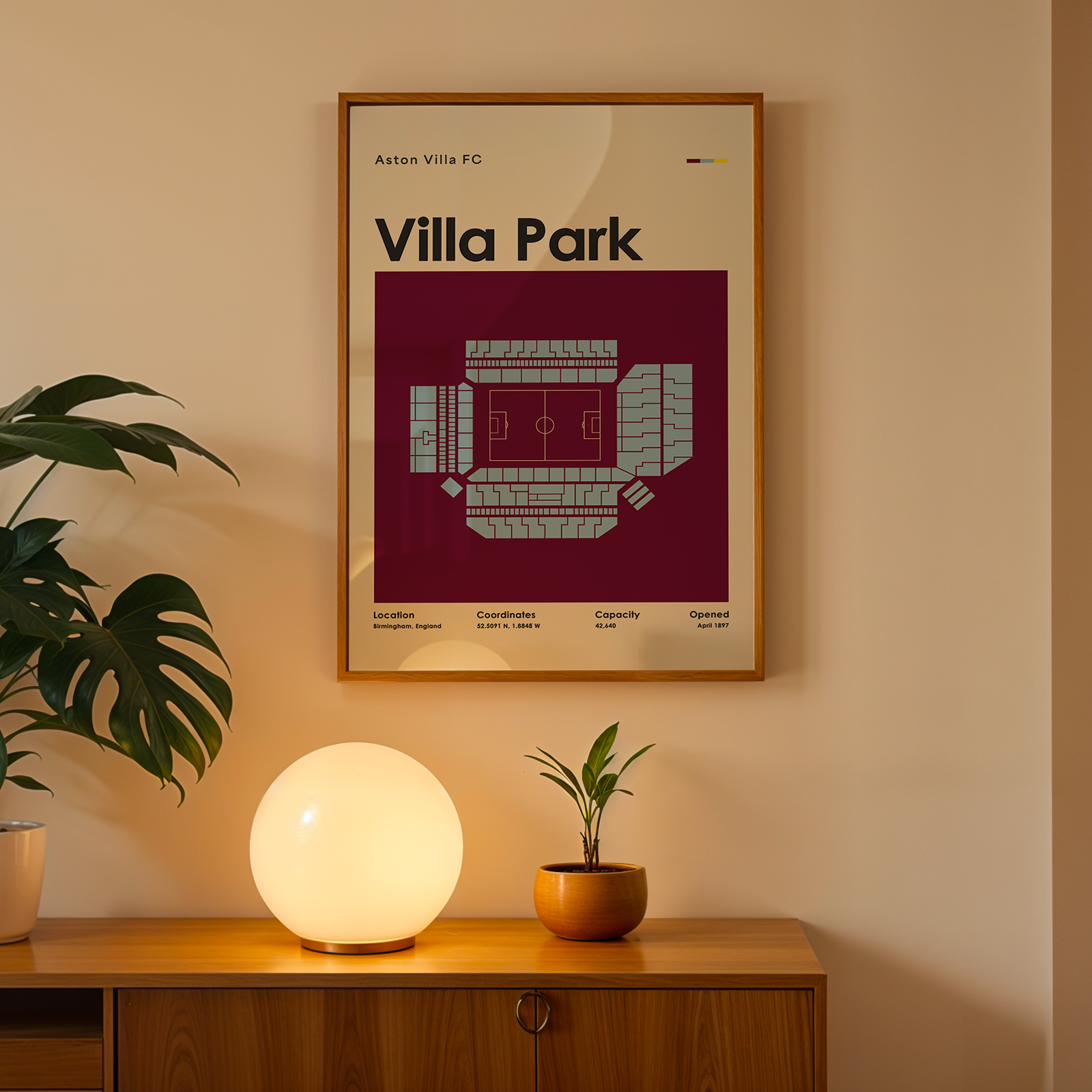 Framed poster of 'Villa Park' on a wall above a wooden cabinet with decorative items.