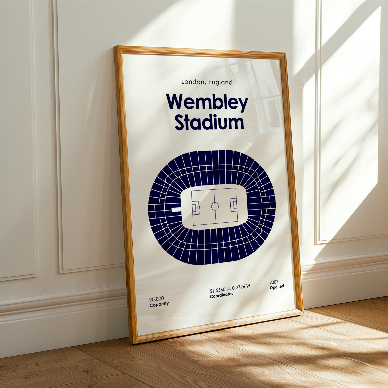Framed poster of Wembley Stadium in London, England on a wall.