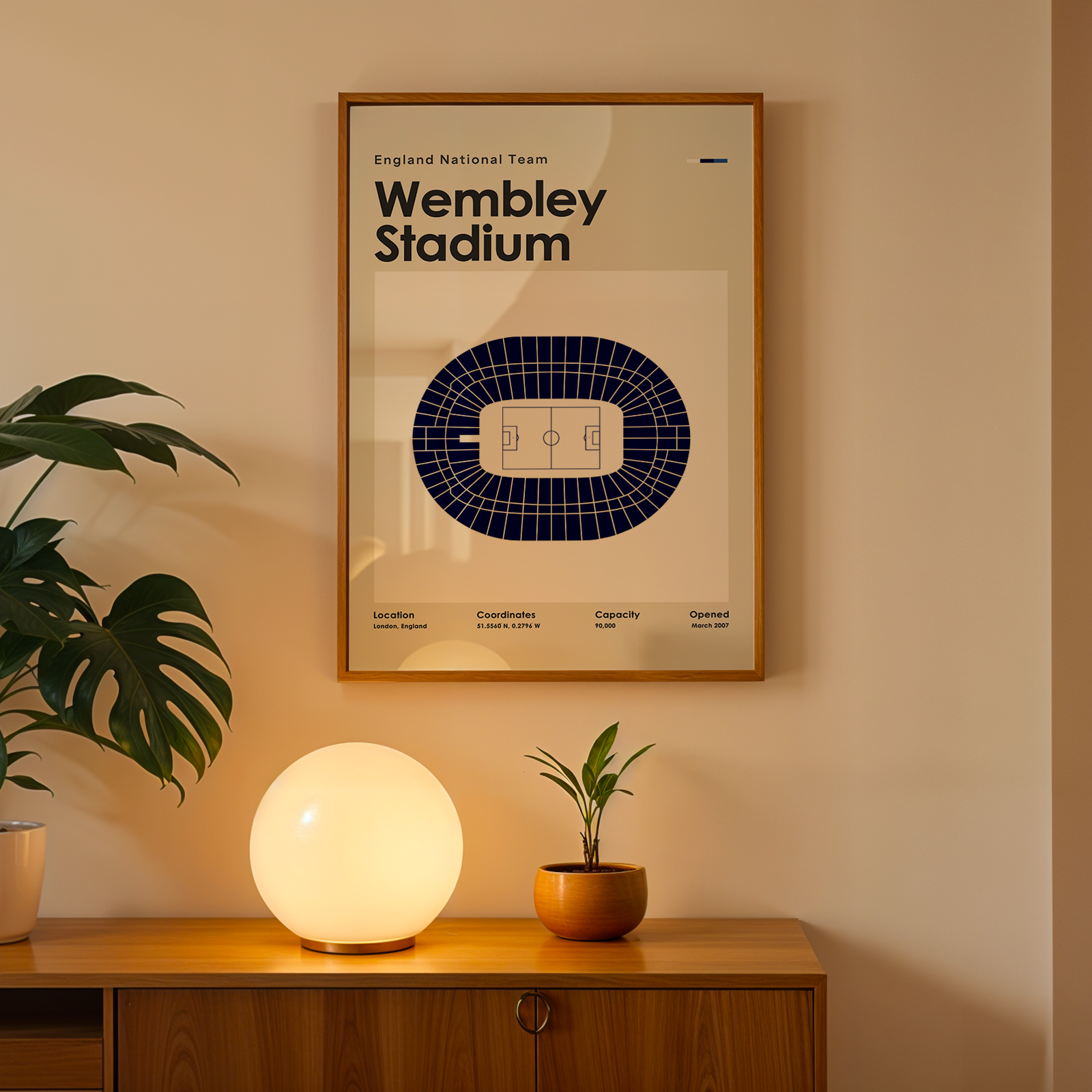 Framed poster of Wembley Stadium on a wall above a wooden cabinet with decorative items.
