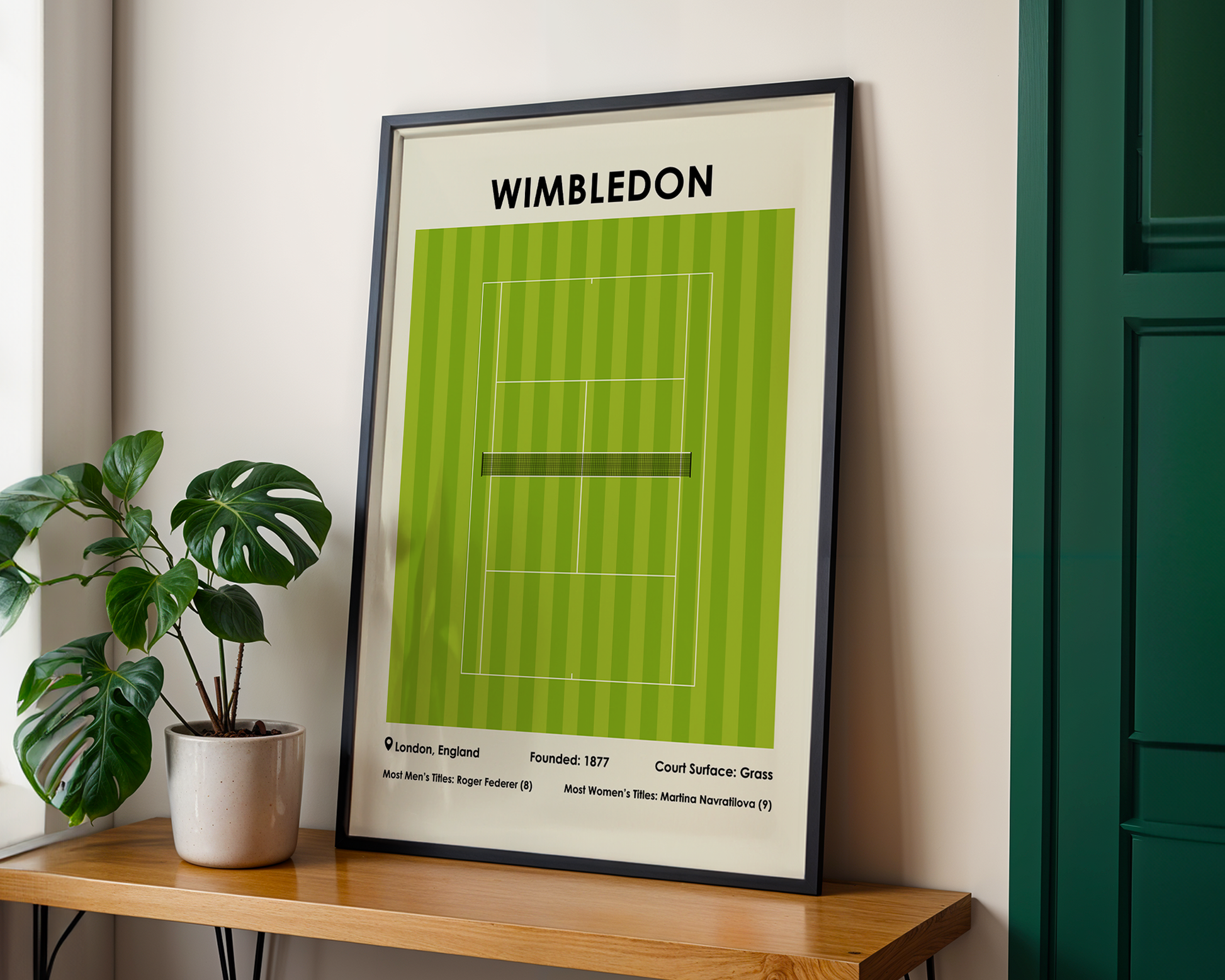 Framed poster of Wimbledon tennis court design on a wall with a plant and wooden shelf.
