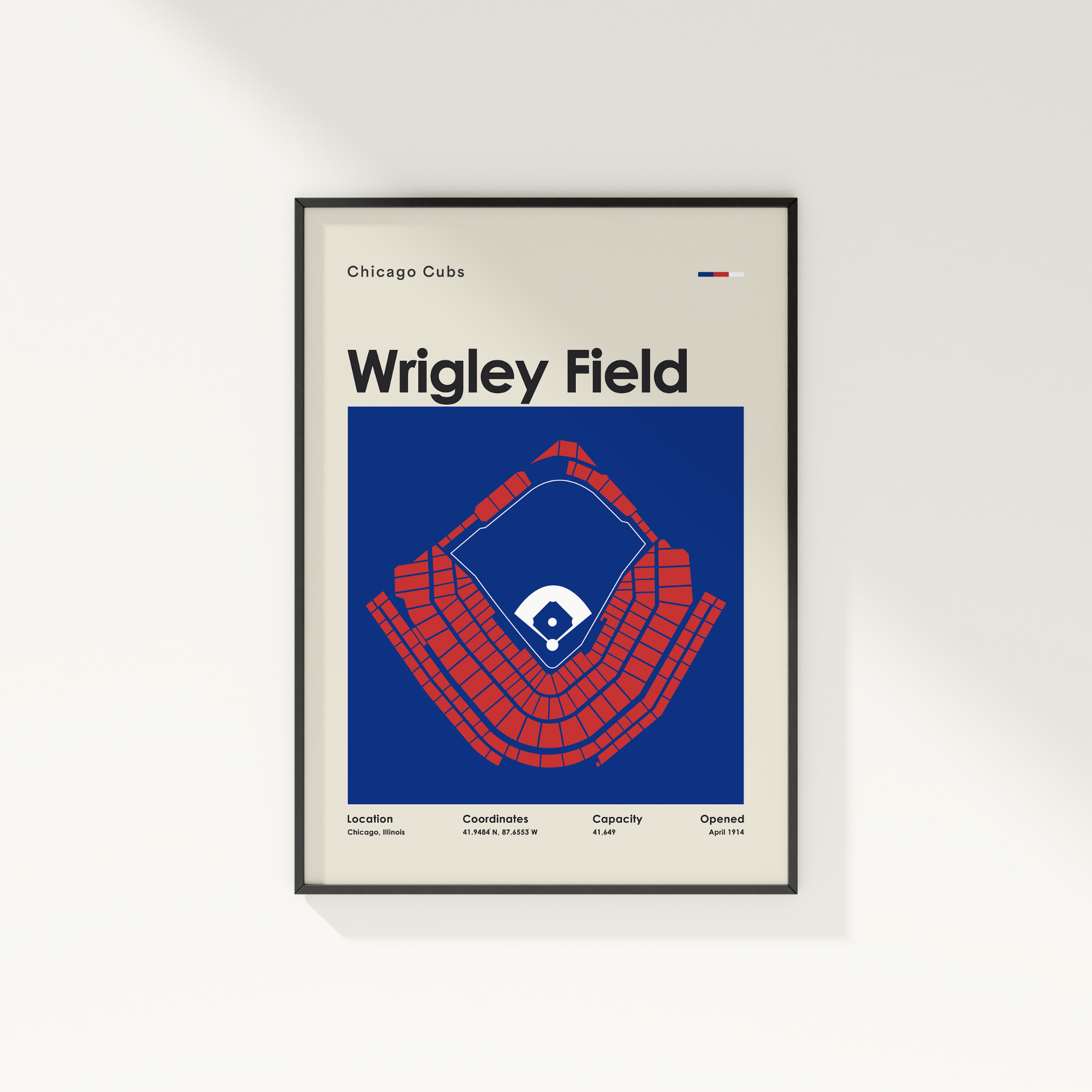 Framed poster of Wrigley Field with Chicago Cubs logo on a white wall