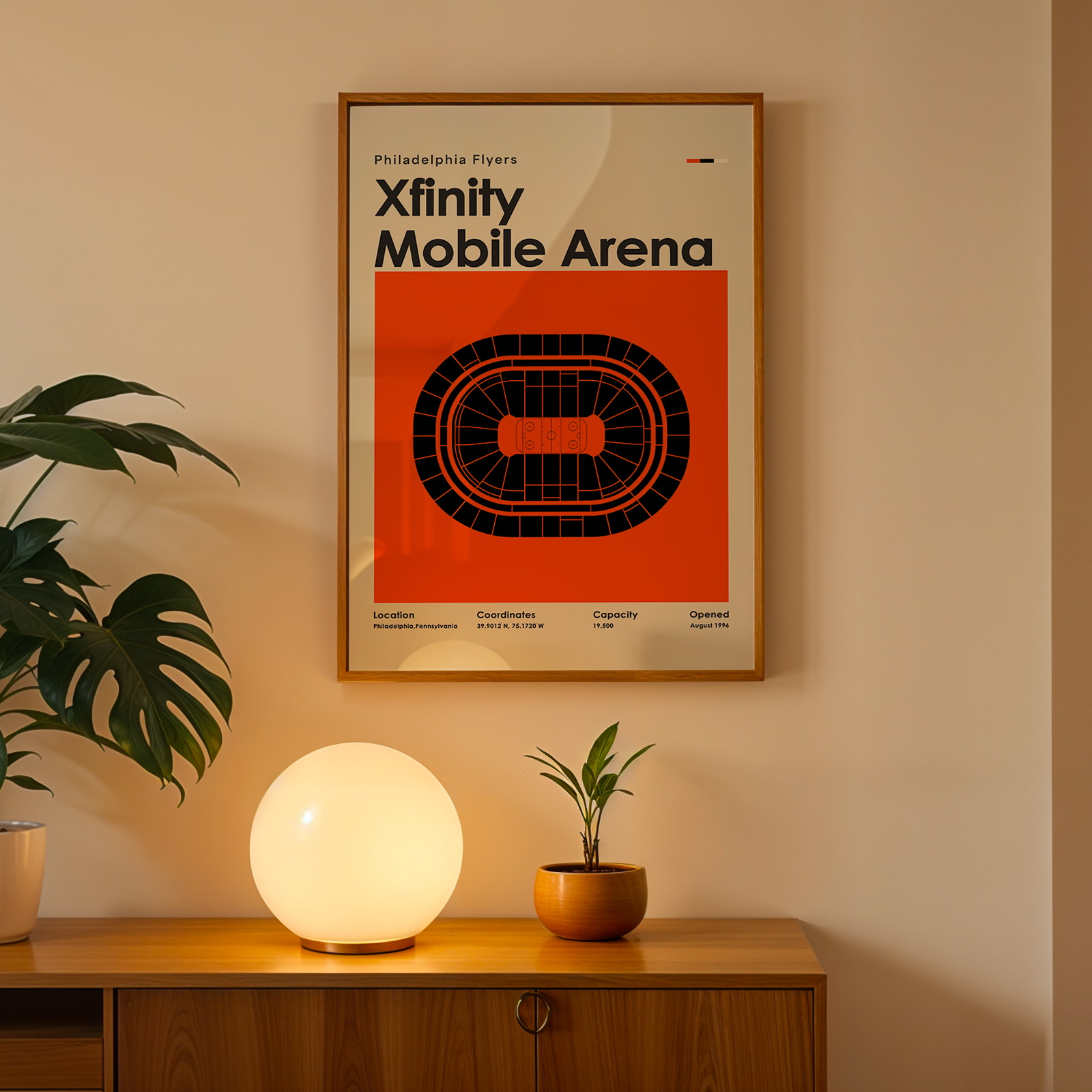 Framed poster of Prudential Center on a wall above a wooden cabinet with decorative items.