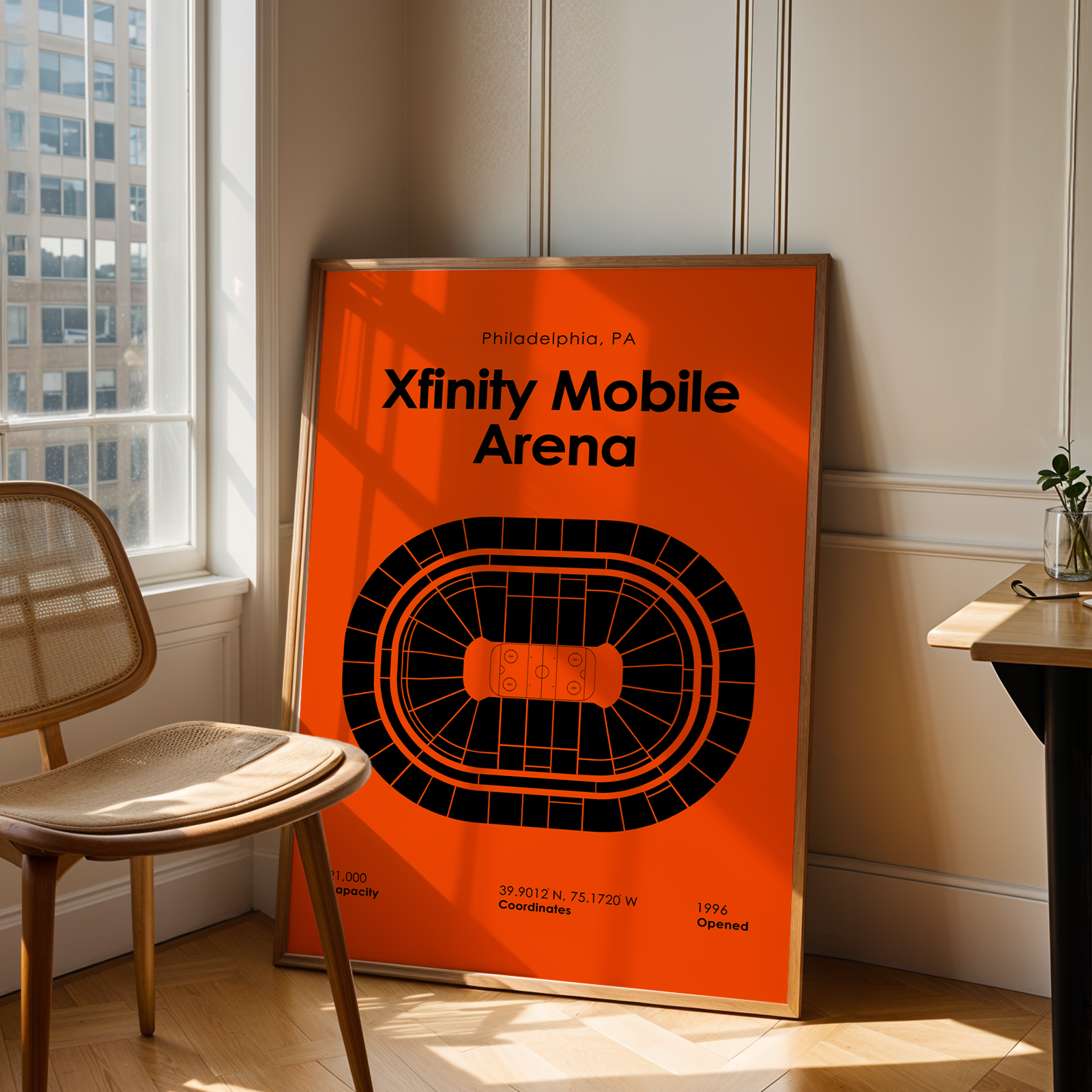 Poster of Xfinity Mobile Arena in Philadelphia, PA, leaning against a wall in a room with a chair and window.