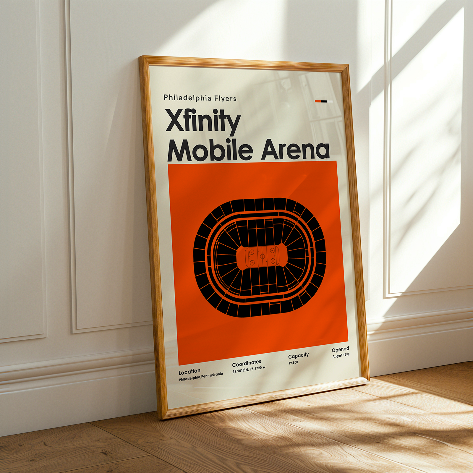 Framed poster of Xfinity Mobile Arena on a wall with sunlight casting shadows.