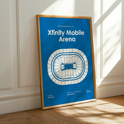 Framed poster of Xfinity Mobile Arena in Philadelphia on a wooden floor with sunlight streaming in.