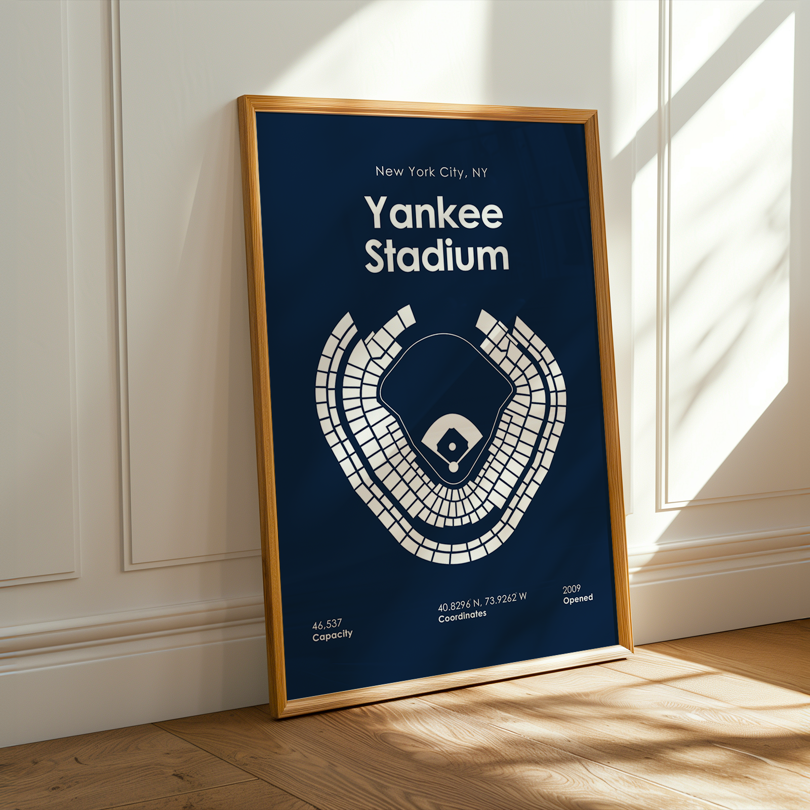 Framed poster of Yankee Stadium layout on a wall with sunlight casting shadows.