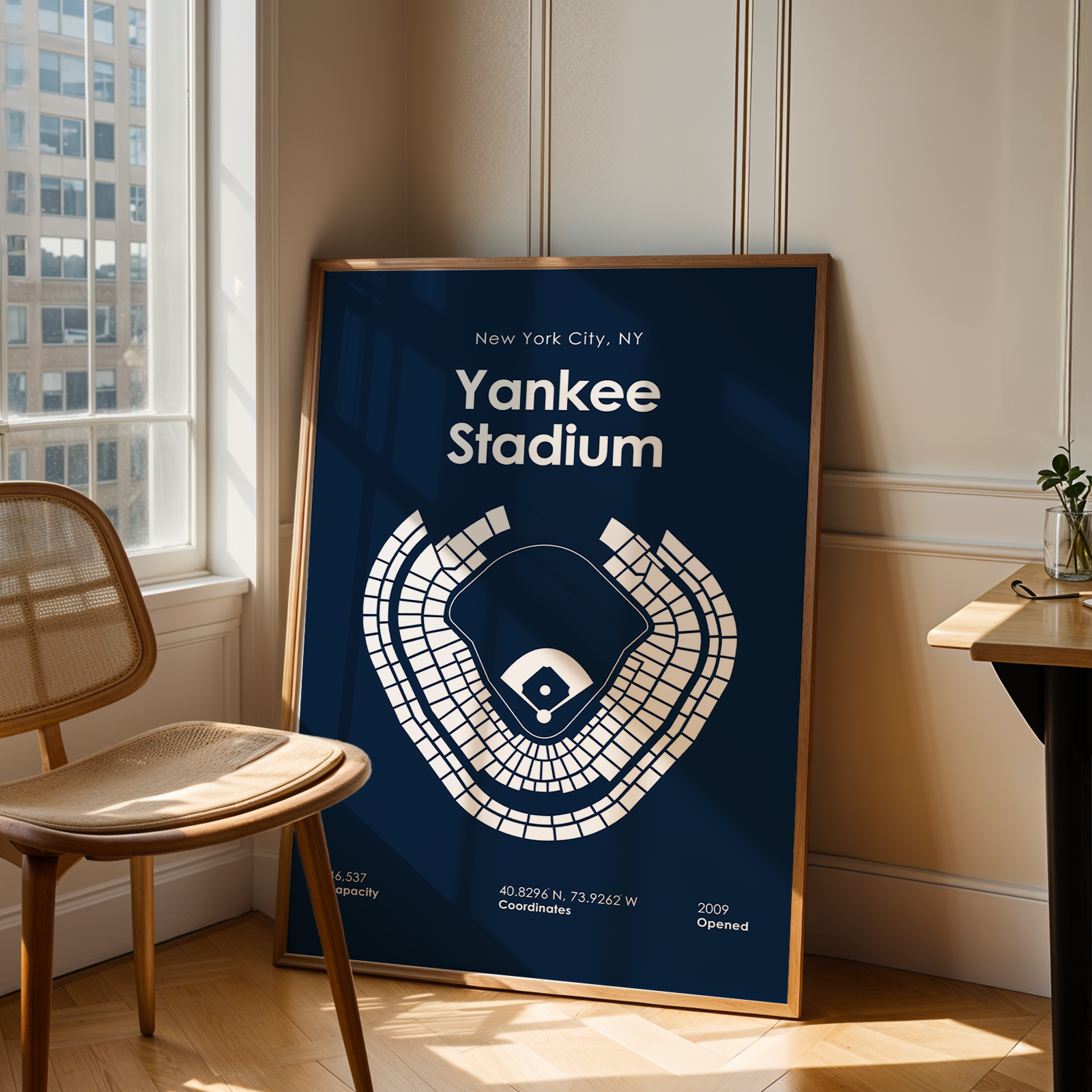 Framed poster of Yankee Stadium layout in a room with a window and chair.