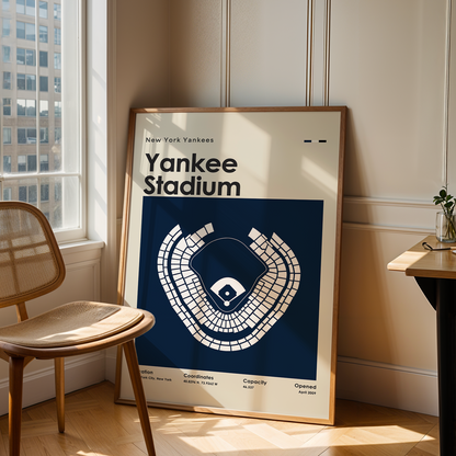 Framed poster of Yankee Stadium in a room with a chair and table.